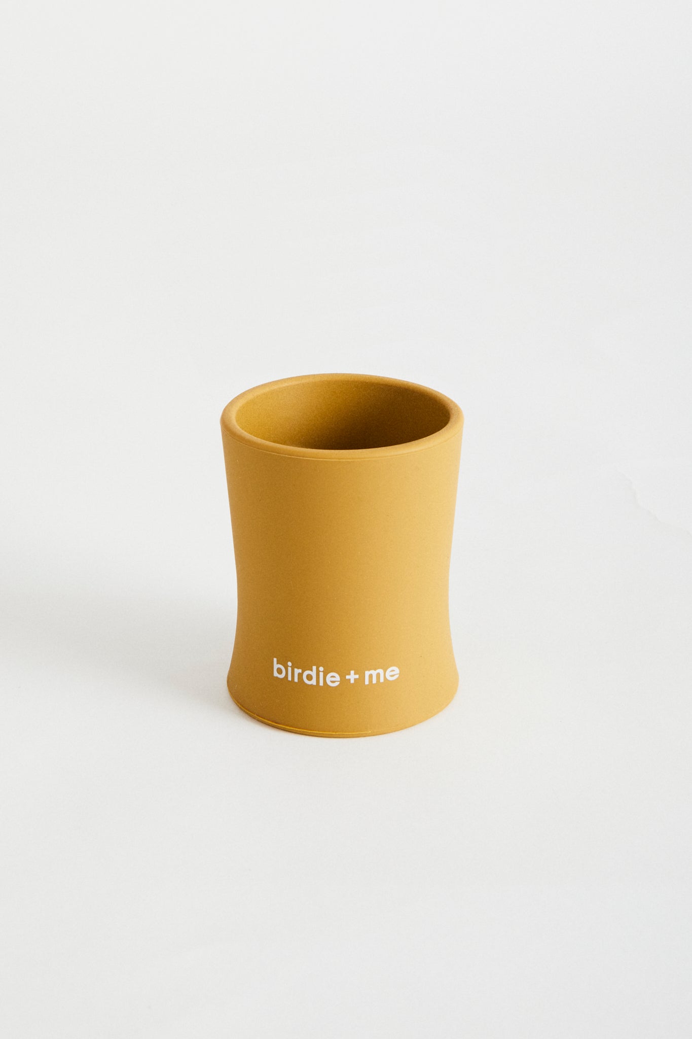 Silicone cup in Clay, birdie + me logo along bottom.