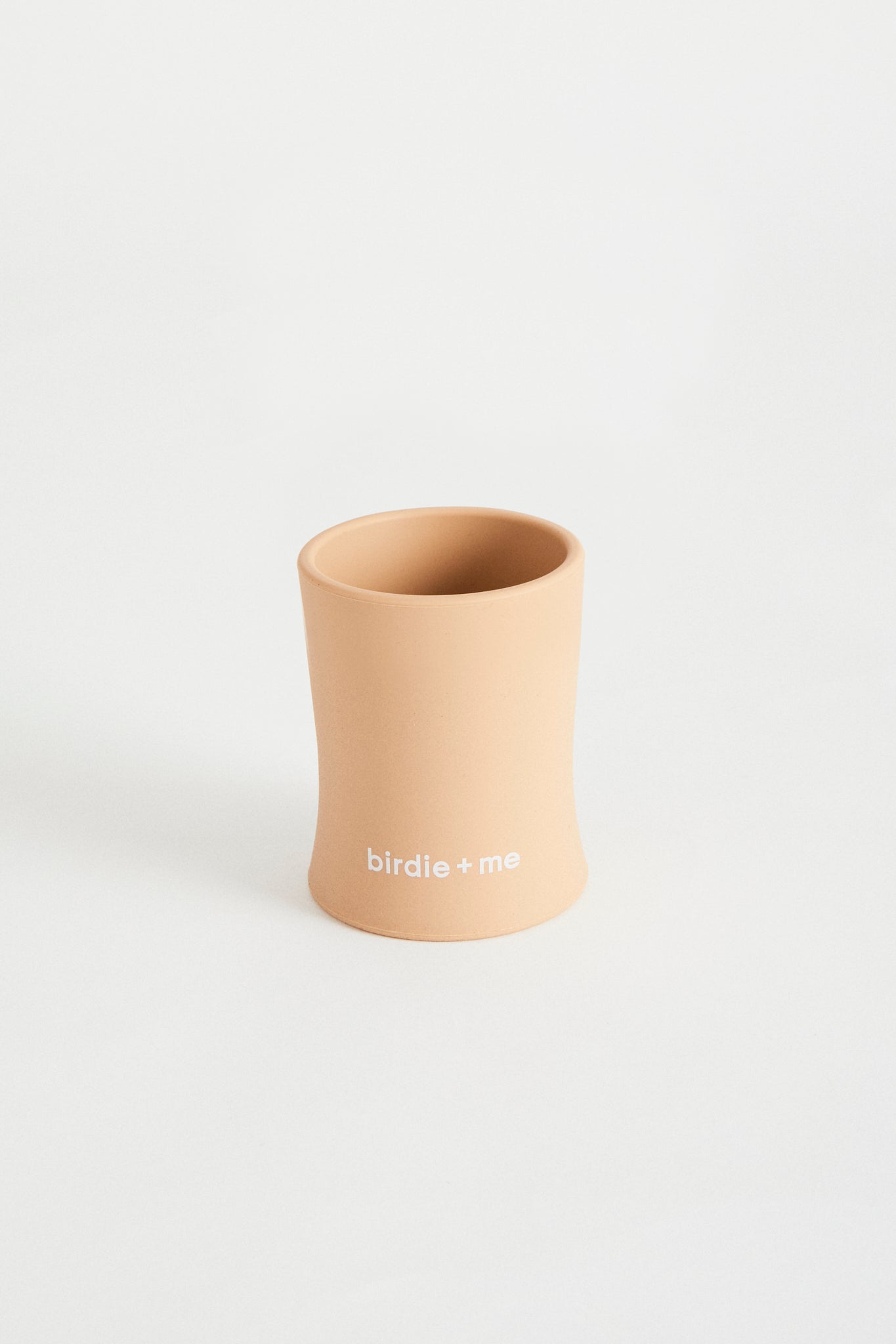 Silicone cup in blush, birdie + me logo along bottom.