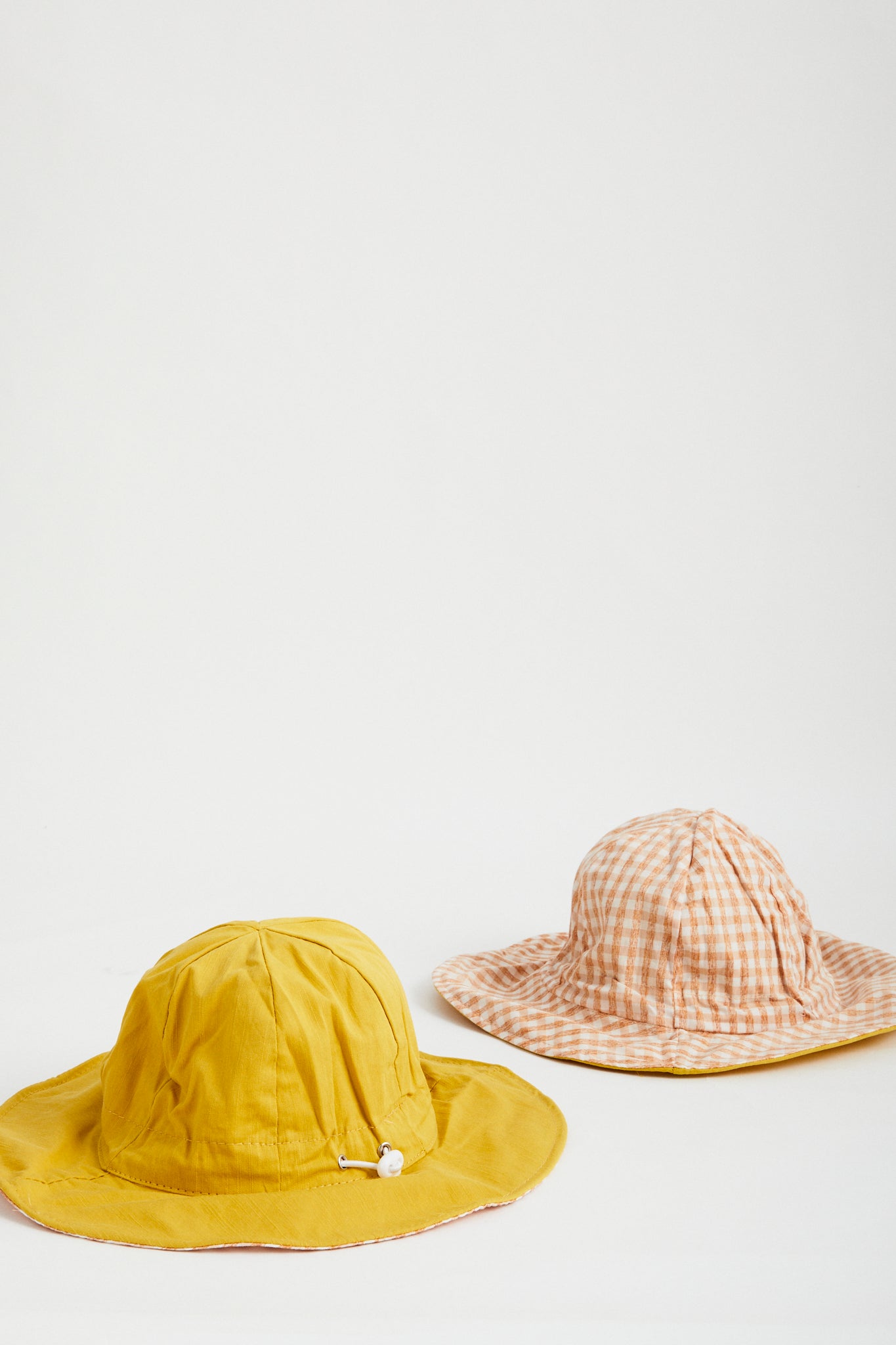 Sunshine Gingham reversible sun hat. Drawstring toggle and wire brim.