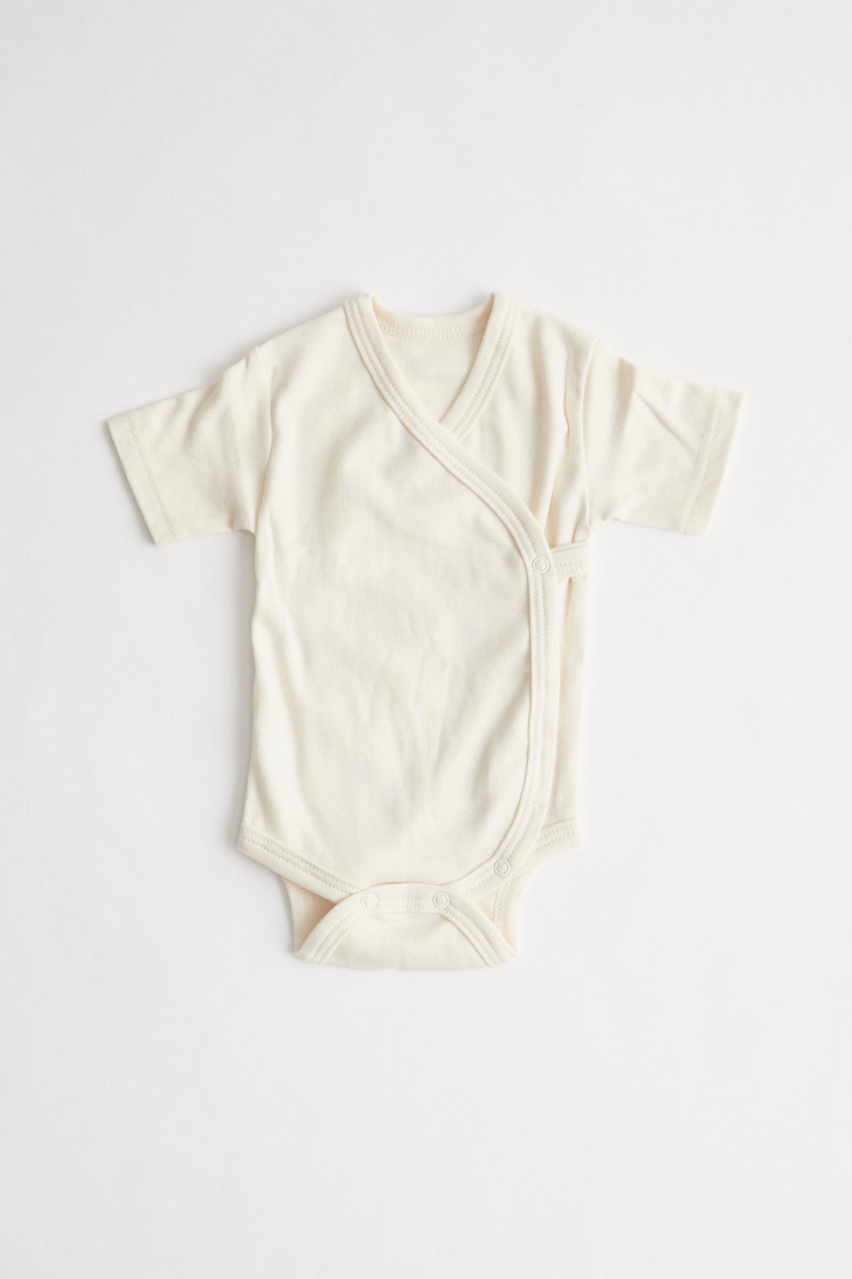 Kimono style organic cotton baby onesie. Packed in drawstring bag.