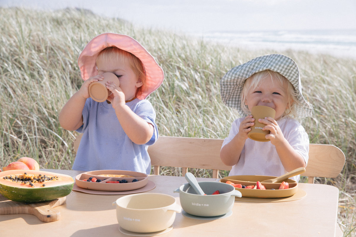 Toddlers drinking from silicone cups.