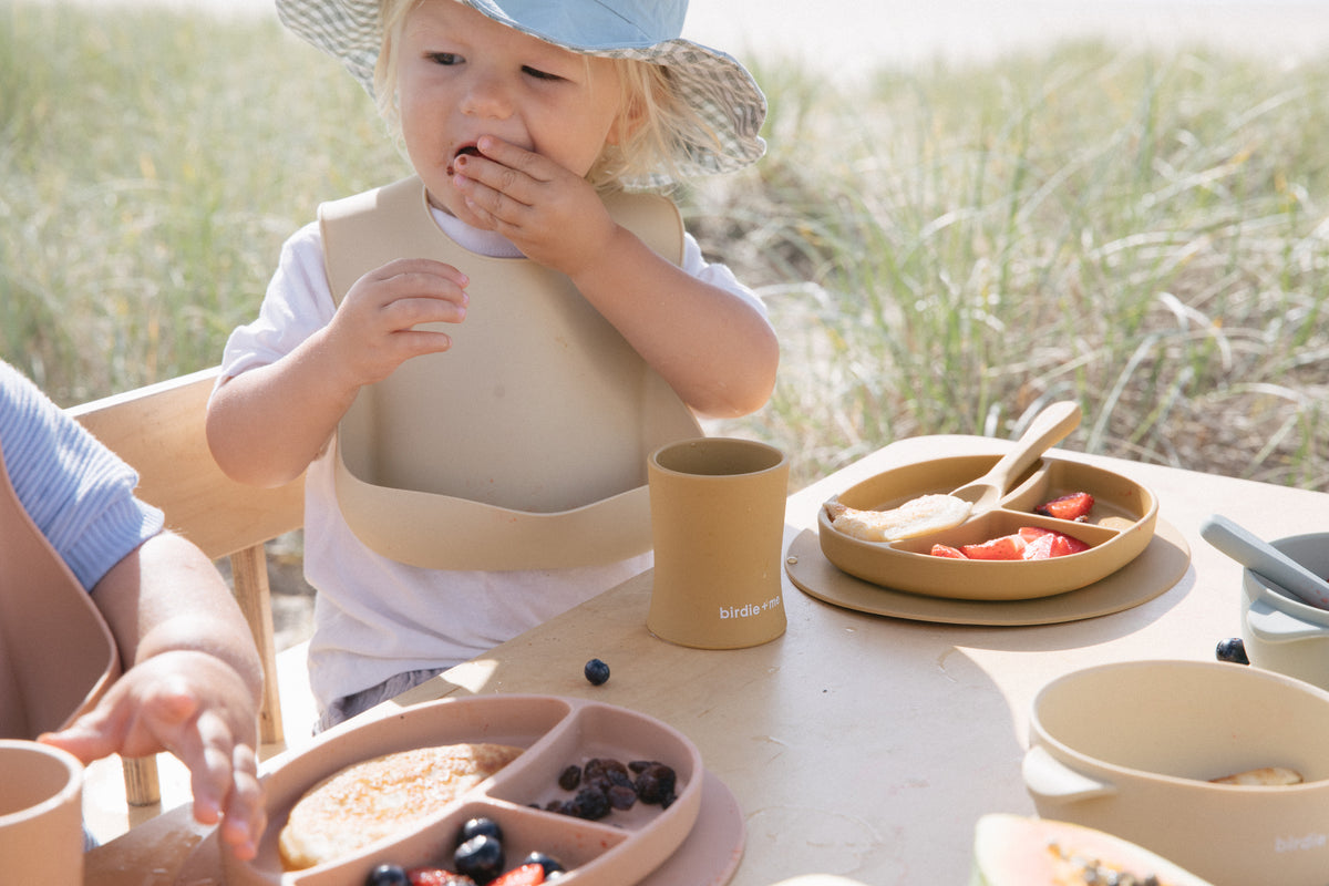 Toddlers drinking from silicone cups.