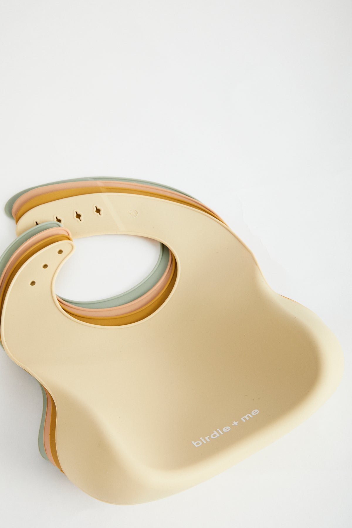 Silicone bib from the back, branded with birdie + me along the bottom.