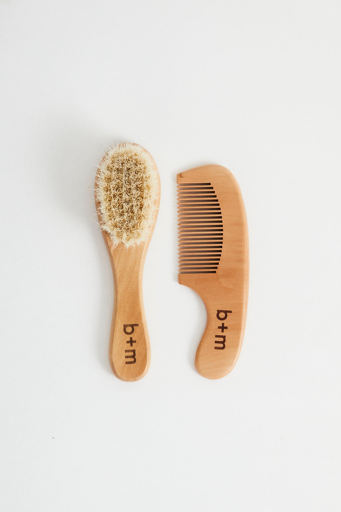baby wooden brush and comb set with goat hair bristles. b + m engraved on handles. 