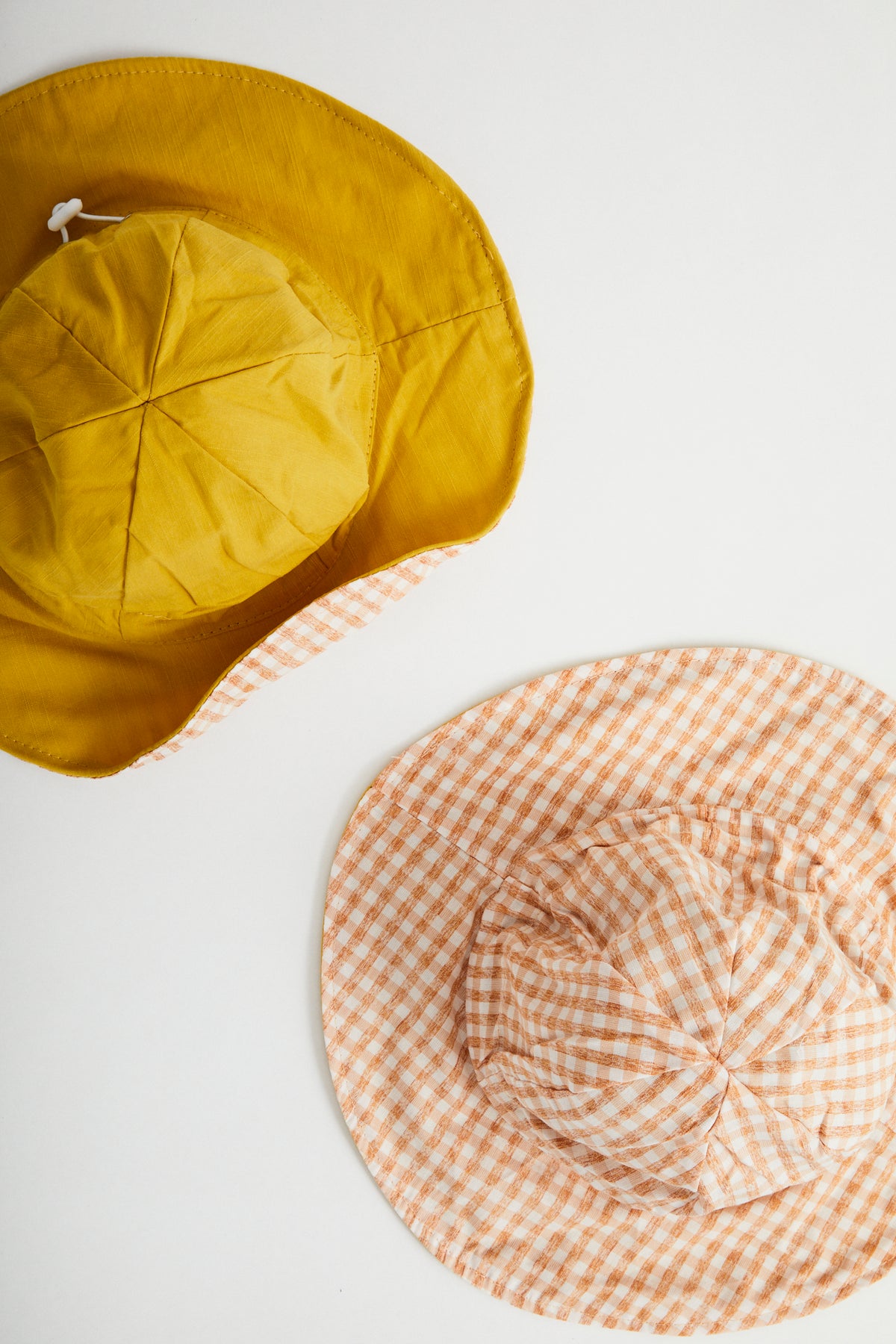 Sunshine Gingham reversible sun hat. Drawstring toggle and wire brim.