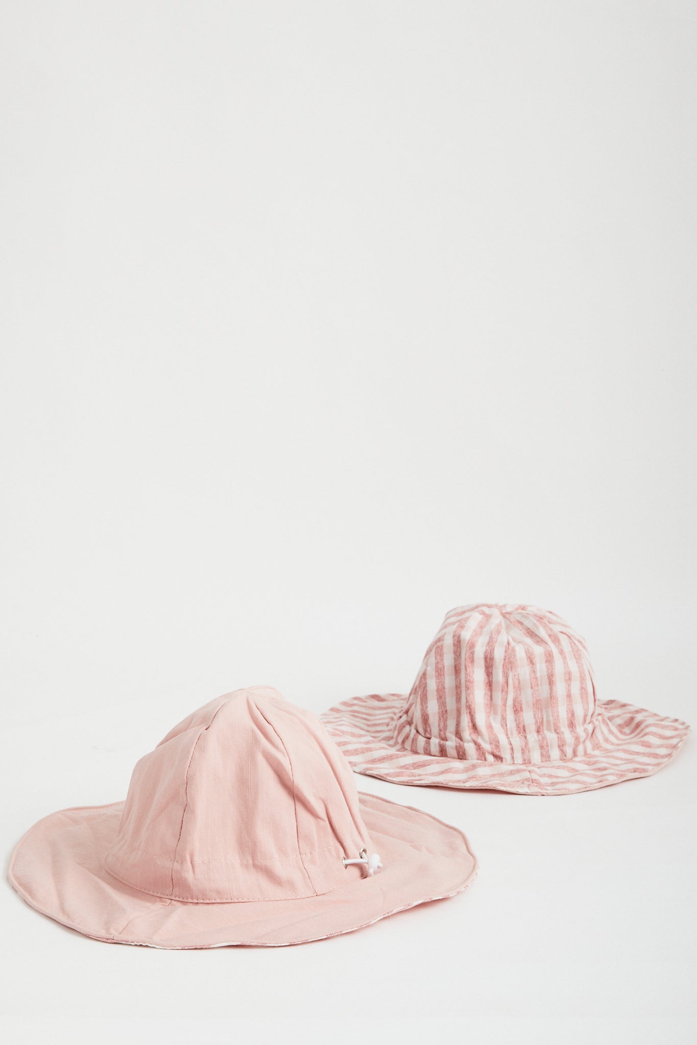 Blush Gingham reversible sun hat. Drawstring toggle and wire brim.