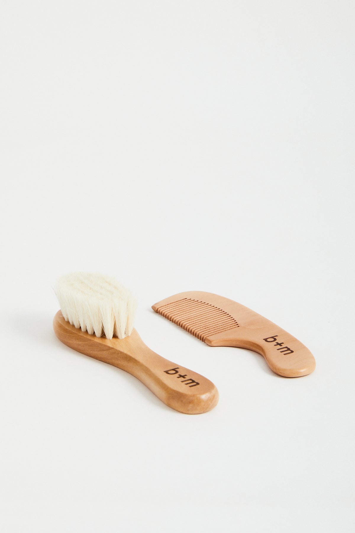 baby wooden brush and comb set with goat hair bristles. b + m engraved on handles. 