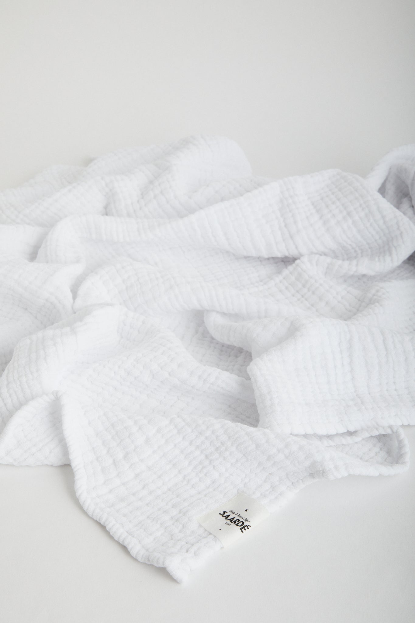 Muslin Crinkle Baby Blanket in White. Saarde logo stitched on corner. 