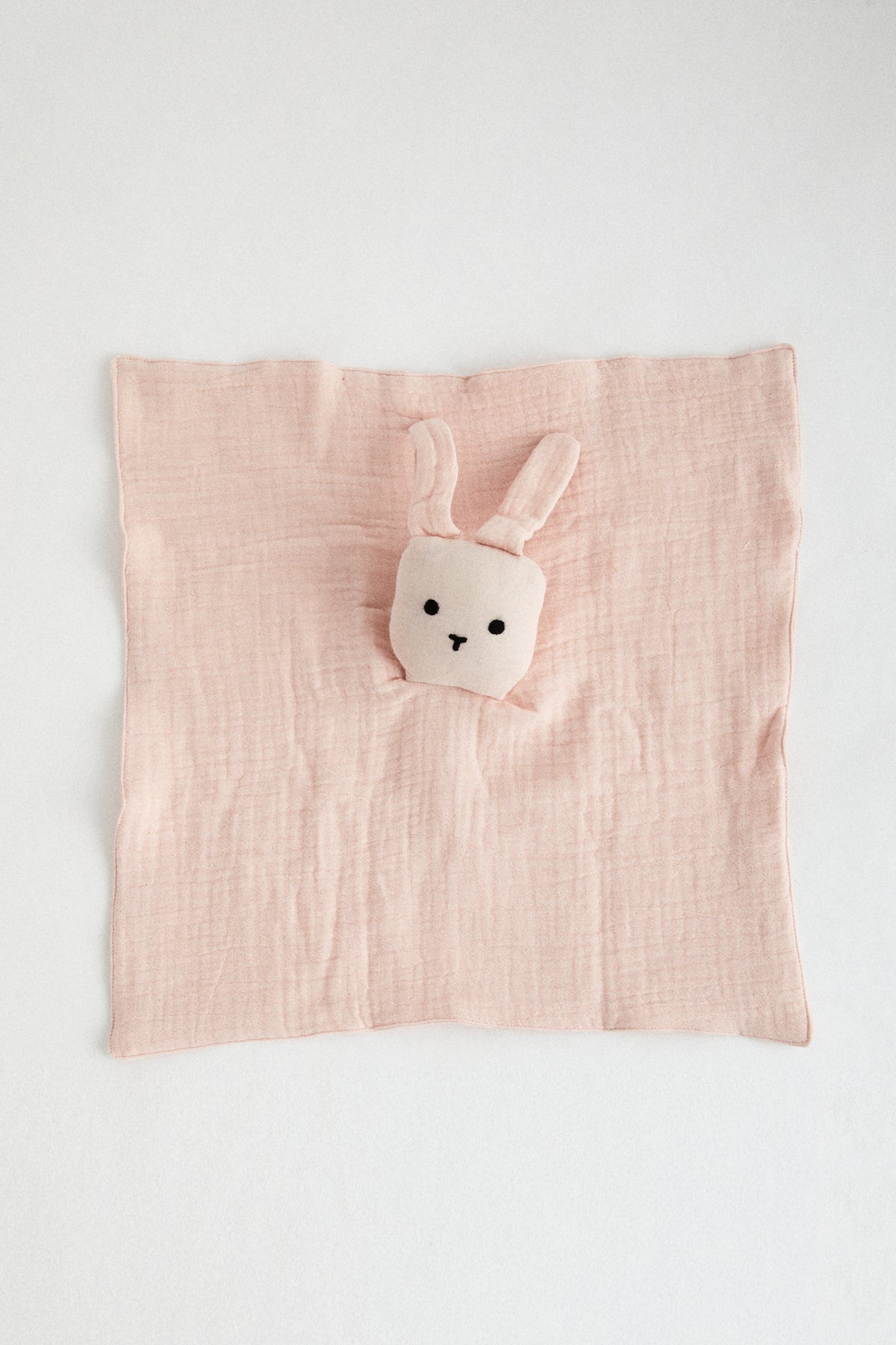 Pale Pink organic muslin lovey with bunny head and floppy ears.