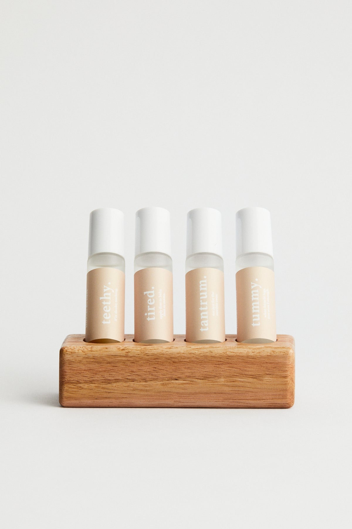 Essential oil roller bottles x 4 in wooden stand. teethy, tired, tantrum, tummy
