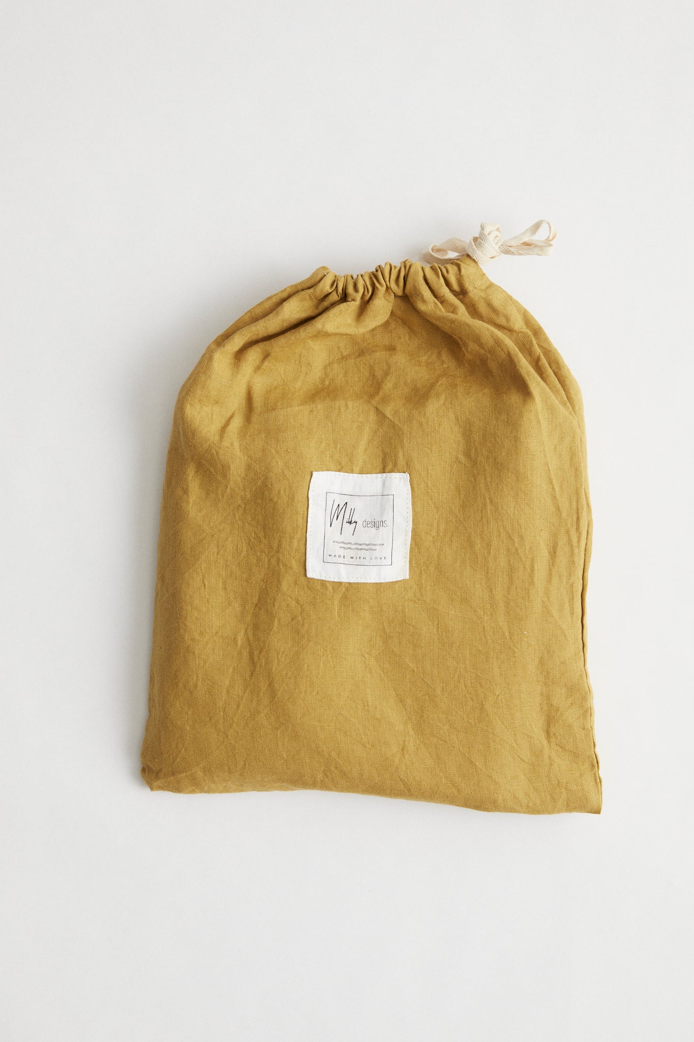 Ochre linen cot sheet. Comes in Ochre linen drawstring bag.