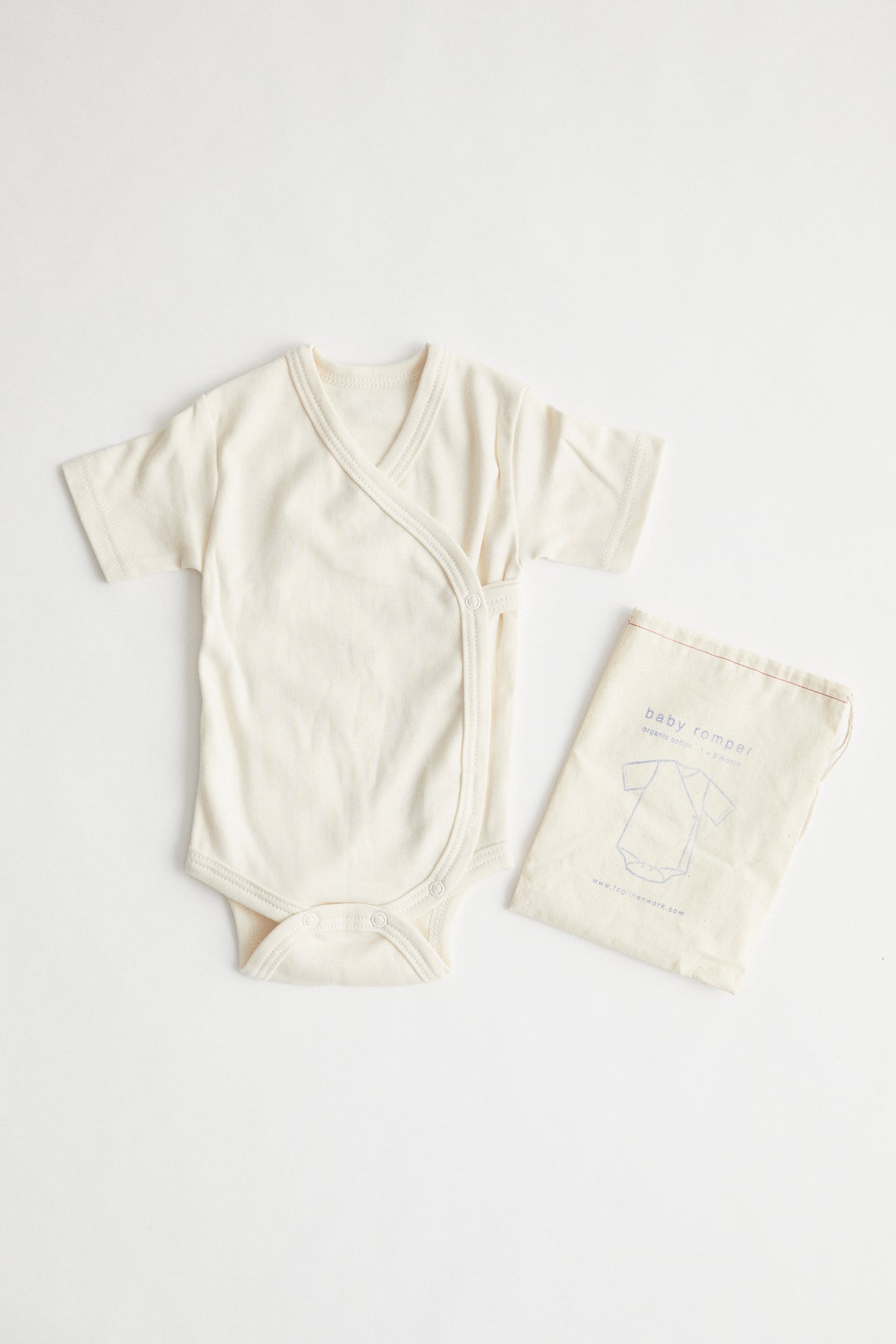 Kimono style organic cotton baby onesie. Packed in drawstring bag.