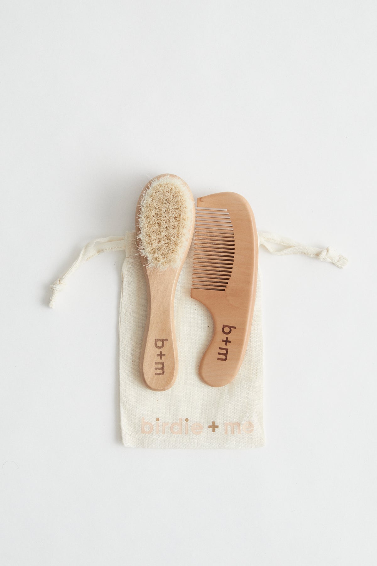 baby wooden goat hair brush and comb set. b + m engraved on handles. Birdie + Me muslin bag