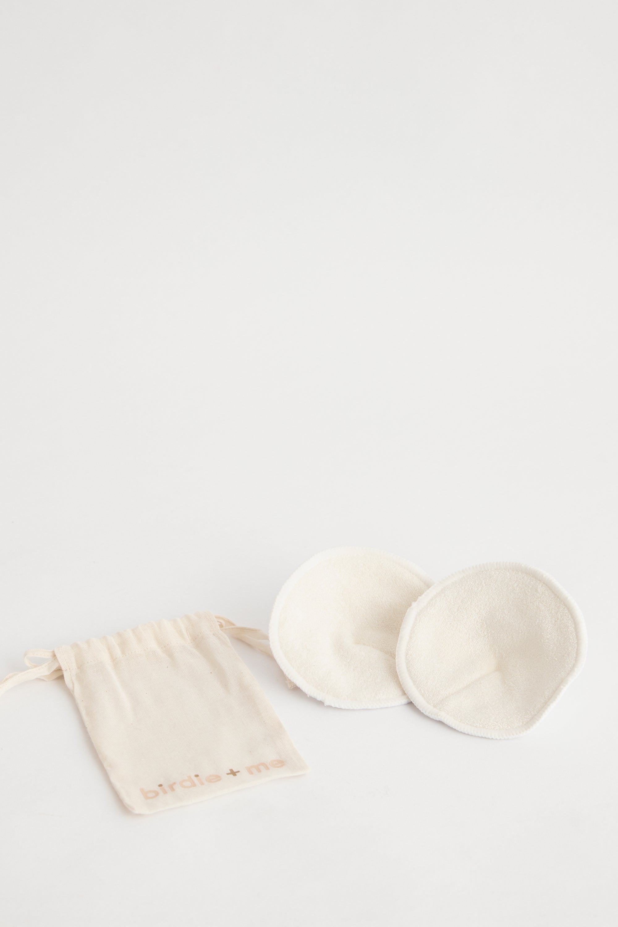 White organic bamboo & cotton breast pad set. In birdie + me calico bag.