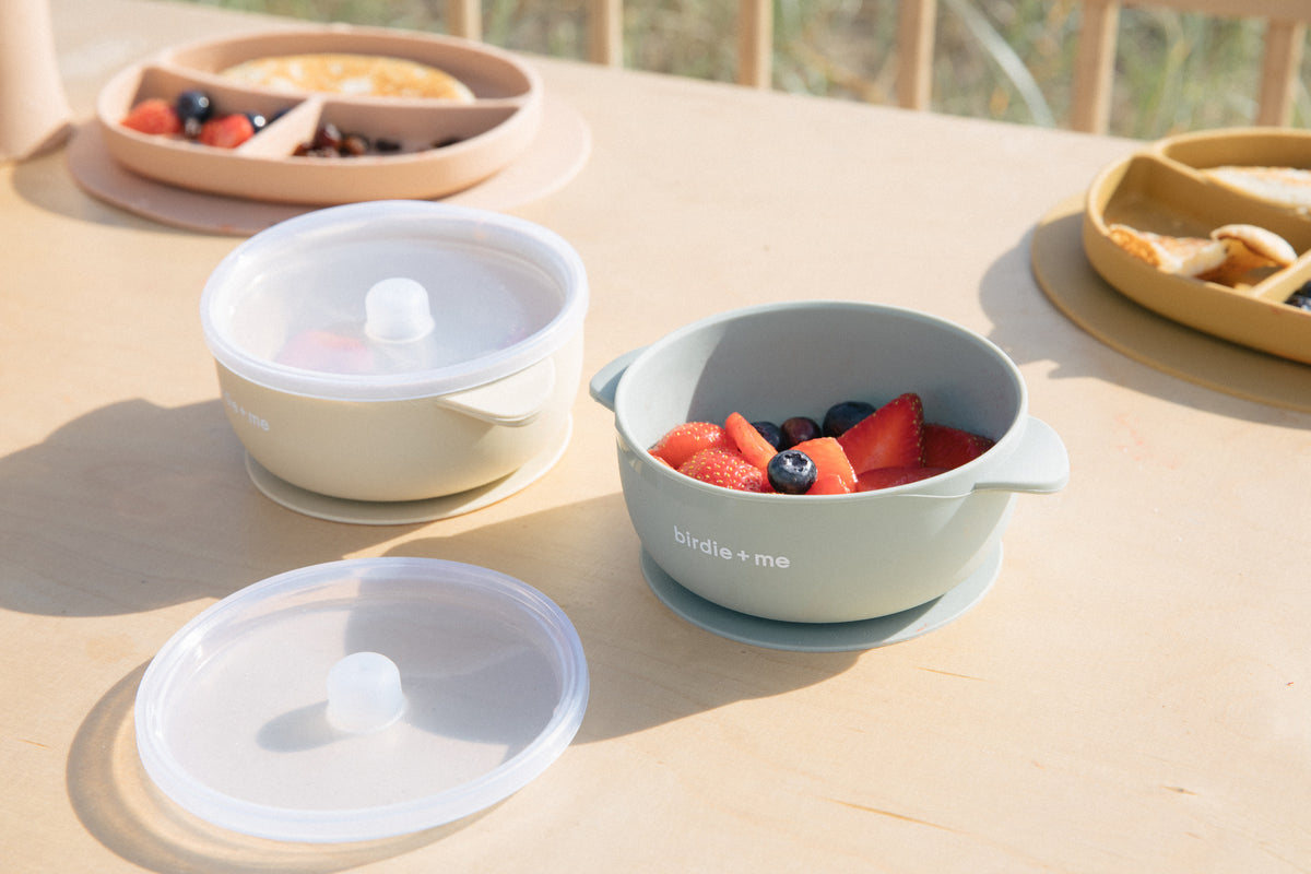Silicone bowl with suction bottom and lid. Branded with birdie + me logo.