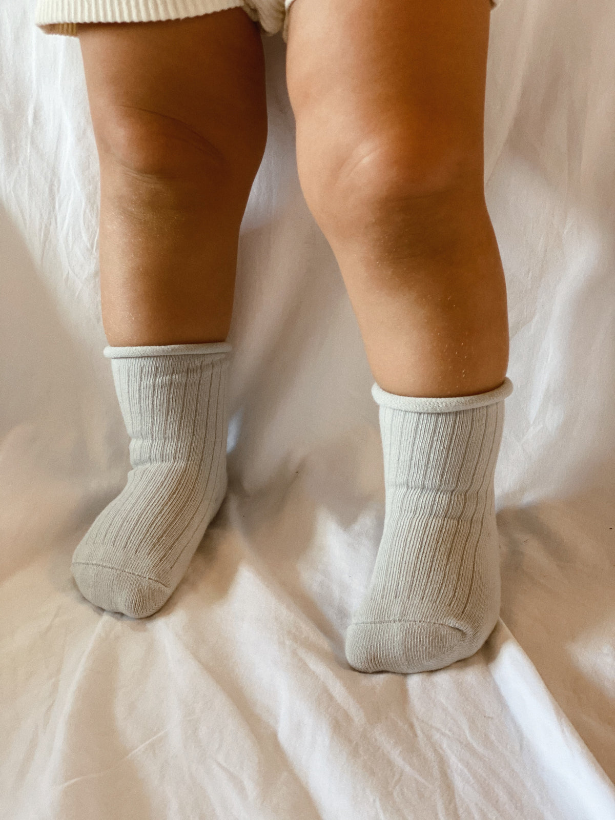 Sky coloured ribbed socks, rolled hem.
