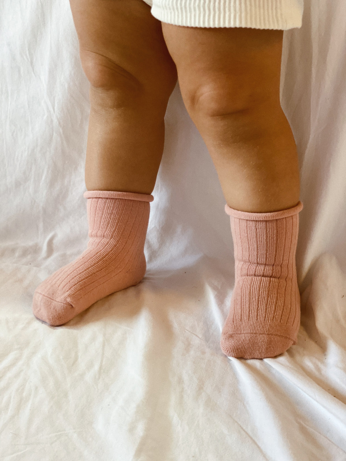 Rose coloured ribbed socks, rolled hem.